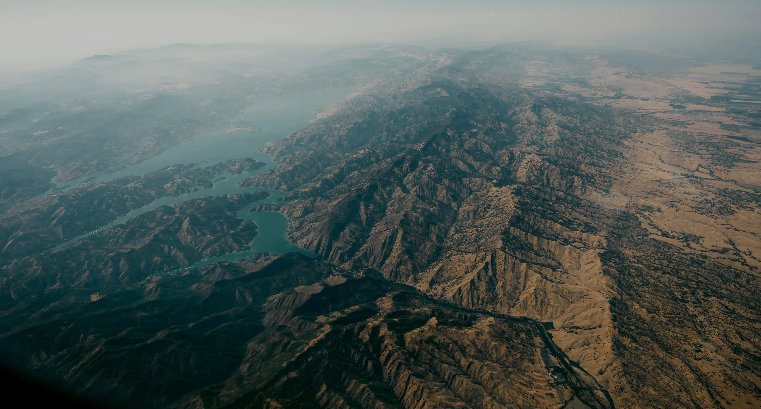 quarter view of the Eearth from space, showing topography of mountains, bodies of water, and atmosphere